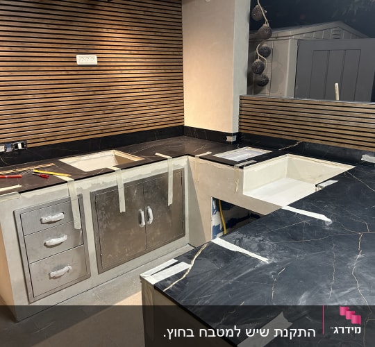שיש מותקן במטבח עם כלים וסרט דבק